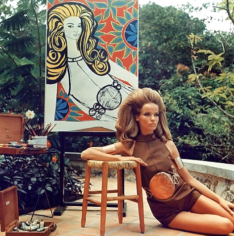veruschka-is-posing-for-artist-genaro-de-carvalho-who-paints-a-colorful-graphic-portrait-of-her-as-she-is-wearing-a-brown-split-leg-halter-one-piece-by-ginori-with-big-round-copper